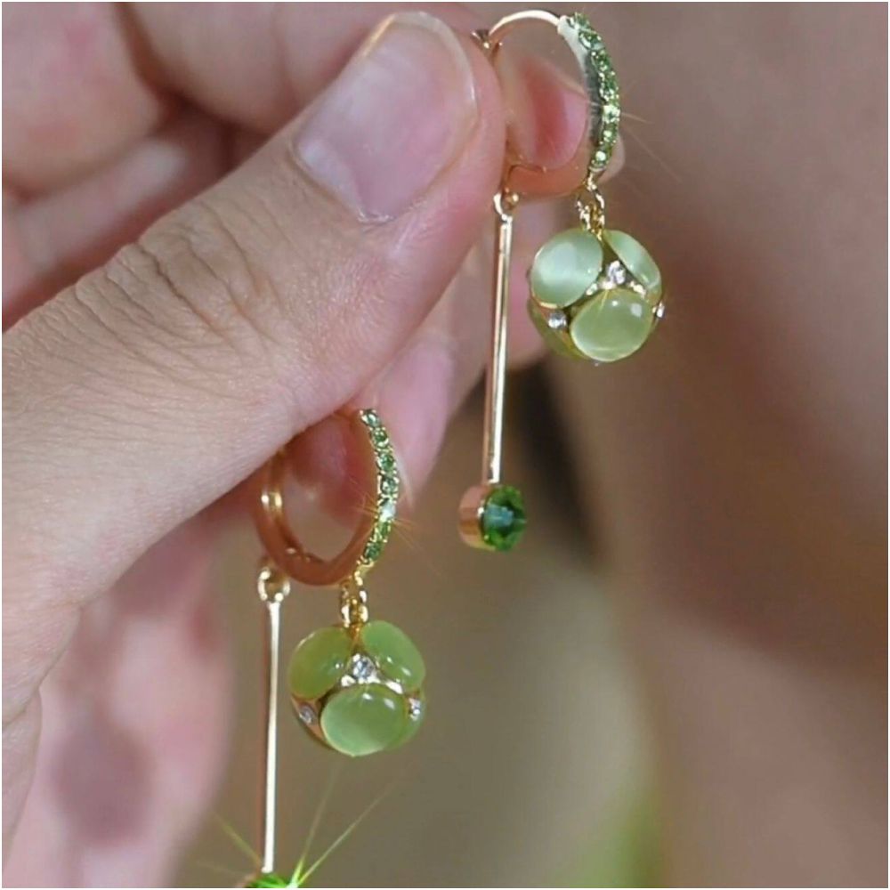 Spring and summer new cat eye stone ball tassel earrings for women with a high end feel micro inlaid ear buckles light luxury temperament face slimming earrings